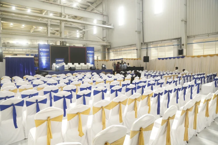 Rows of dressed chairs set in a factory hall for a company address