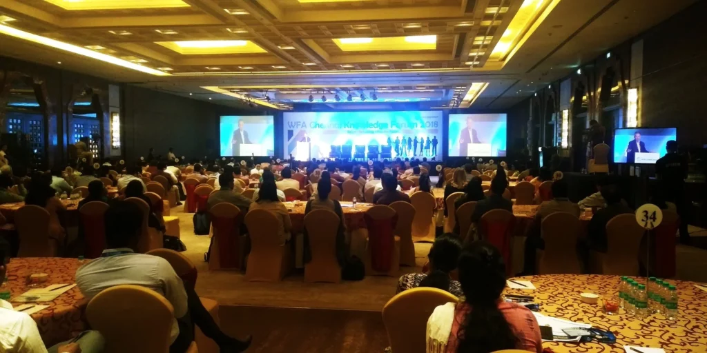 A full conference hall with relay screens