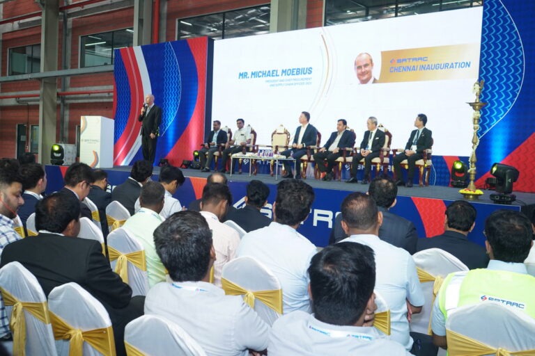 Guests seated before a branded stage and panel at a plant inauguration